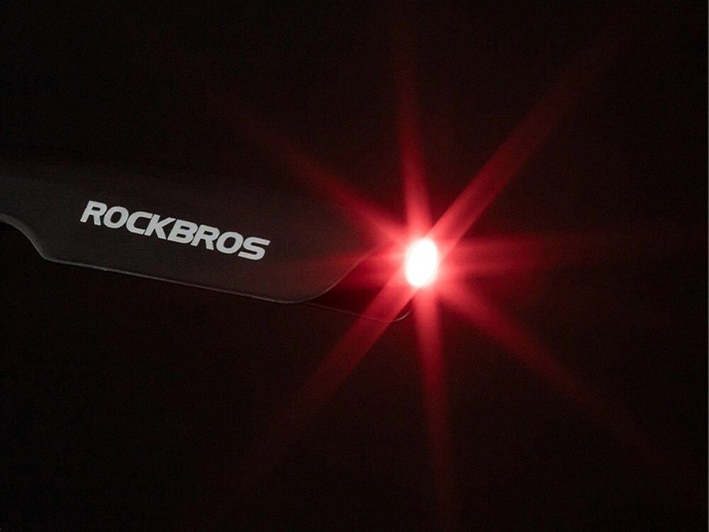 Czarny element z logo \'ROCKBROS\' oraz świecącym na czerwono światłem na ciemnym tle.