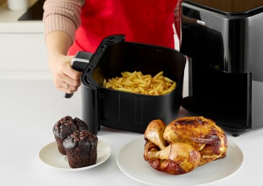 Osoba trzyma kosz frytownicy MFR-11 wypełniony frytkami. Obok kurczak i babeczki.