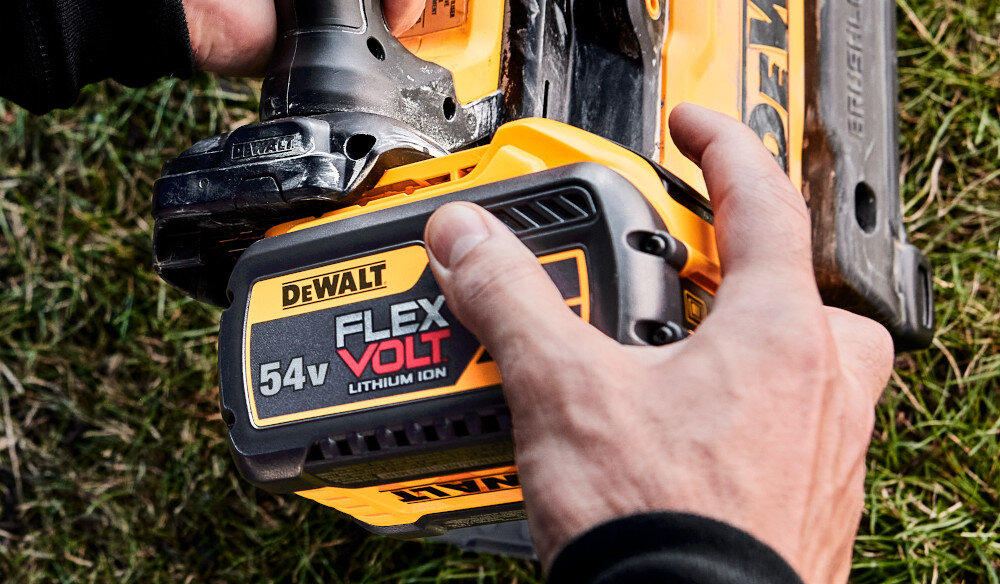 Dmuchawa do liści akumulatorowa DEWALT DCMBL777X1-QW (z akumulatorem) trawnik osoba trzyma dmuchawę w dłoni zakłada akumulator na dmuchawę swobodnie poruszać się współpracuje zarówno z narzędziami 18 V, jak i 54 V akumulator o pojemności 9 Ah do 17 minut pracy na jednym cyklu ładowania w trybie ECO