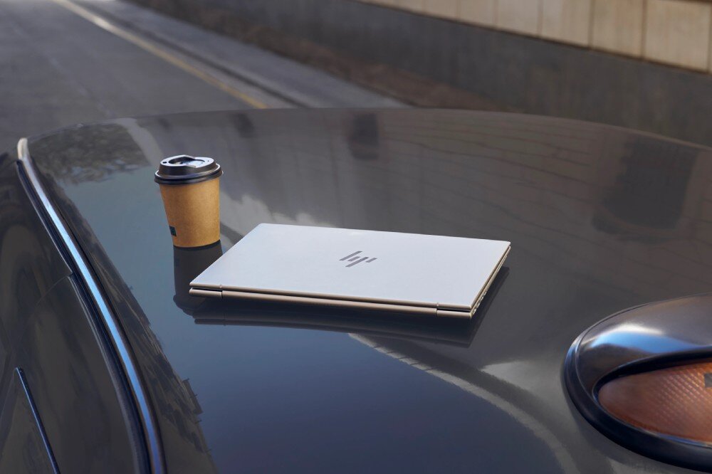 Laptop HP EliteBook 630 G11 Zamknięty laptop leżący obok papierowego kubka z kawą na karoserii samochodu, zabezpieczenia, ochrona, BIOS