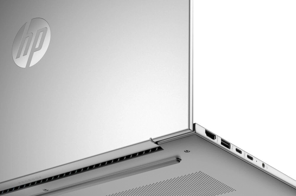 Laptop HP ProBook 445 G11 - zbliżenie na dolną część obudowy laptopa i jego boczne krawędzie. Widoczne porty, otwory wentylacyjne oraz logo producenta, prezentacja łączności Wi-Fi i Bluetooth