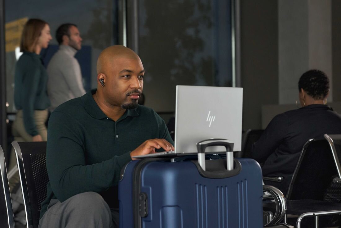 Laptop HP EliteBook 860 - Mężczyzna w pozycji siedzącej, korzystający z laptopa HP EliteBook 860 na krześle.