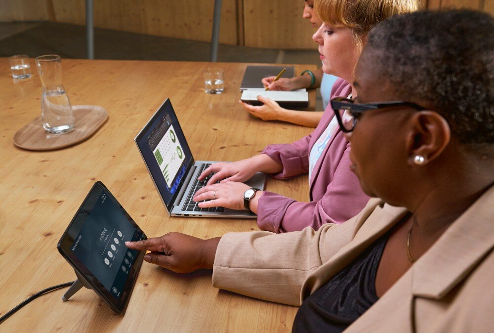 Laptop HP EliteBook 630 G11 Kilka osób siedzących przy stole konferencyjnym, jedna z nich obsługuje tablet, a druga pracuje na laptopie, głośniki, mikrofony, redukcja szumów, dźwięk