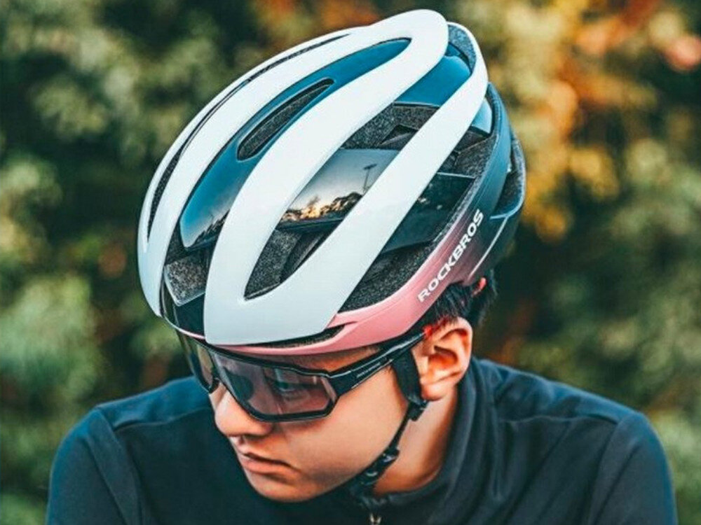Kask rowerowy ROCKBROS 10110004008 Niebiesko-różowy Szosowy (rozmiar M), ochrona, komfort, bezpieczeństwo, lekkość, Rowerzysta w kasku Rockbros 10110004008 w kolorze niebiesko-różowym z okularami ochronnymi.