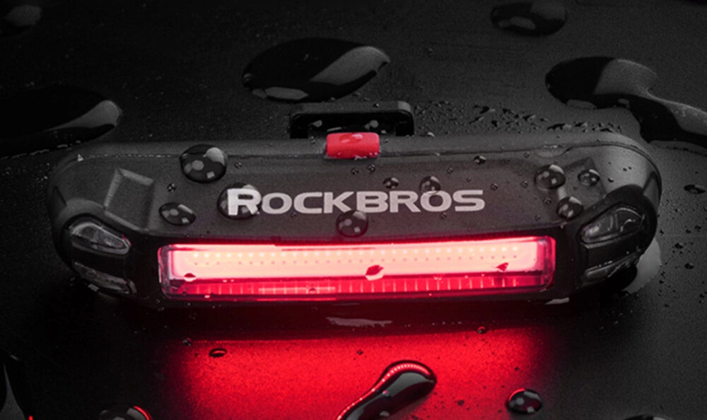 Lampka rowerowa ROCKBROS A54BK ciemne tło mokra lampka leży na mokrej powierzchni montowanie i zdejmowanie lampki jest szybkie elastyczne uchwyty wygodna w codziennym użytkowaniu