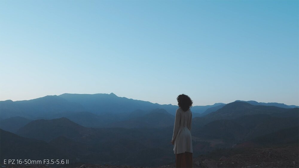 Aparat SONY ZV-E10 II człowiek na tle niskich gór proces twórczy  profil obrazu S-Cinetone Active Mode ustawienia kinowe Vlog