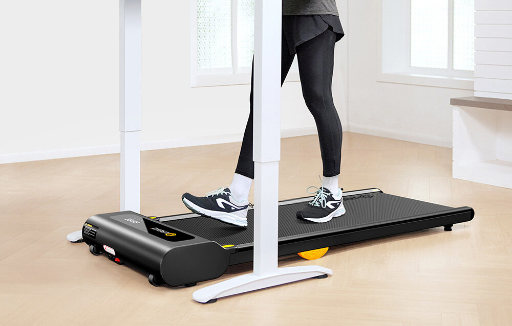 Bieżnia elektryczna UREVO Spacewalk SP1 Lite 1677W 6km-h pokój osoba pracuje przy biurku korzystając z bieżni fitness ćwiczenia w domu