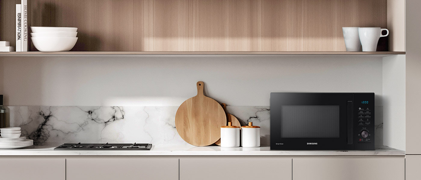 Wolnostojąca kuchenka mikrofalowa Samsung MC28A5135CK pokazana w pomieszczeniu kuchennym o stonowanych kolorach Wolnostojąca kuchenka mikrofalowa Samsung MC28A5135CK pokazana w pomieszczeniu kuchennym o stonowanych kolorach