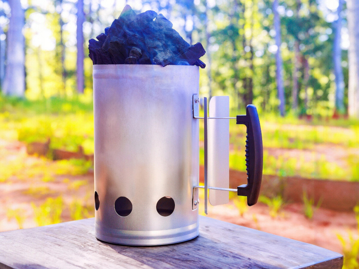 Komin do rozpalania grilla KOLER KRA34, komin, rozpalanie, grill, Koler, komin stoi na stole w lesie w pełni napełniony węglem