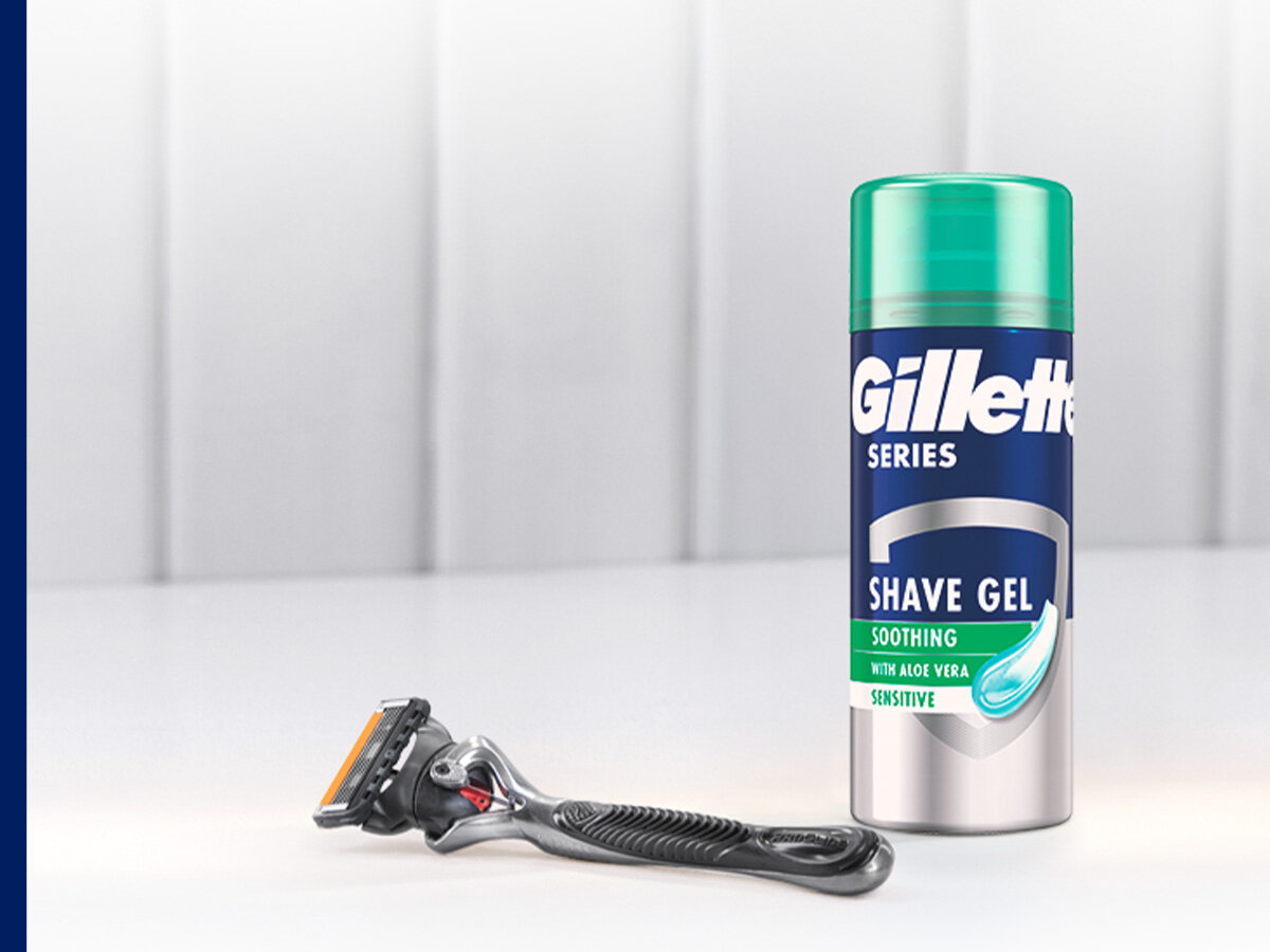 Na obrazie widoczna jest maszynka do golenia oraz puszka żelu do golenia marki Gillette. Na puszce znajduje się napis: \'Gillette Series Shave Gel Soothing with Aloe Vera Sensitive\'.