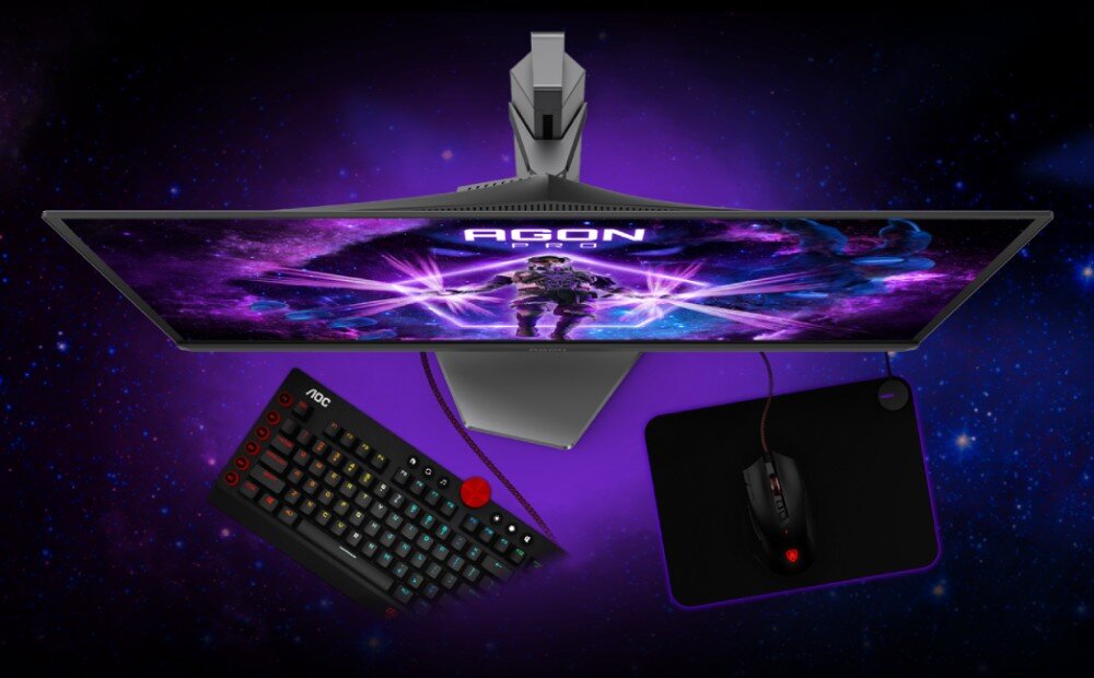 Monitor AOC Agon Pro AG276QZD2 Widok z góry na monitor z ekranem wyświetlającym postać oraz ułożoną pod nim klawiaturę, myszkę i podkładkę, podstawa, miejsce na biurku