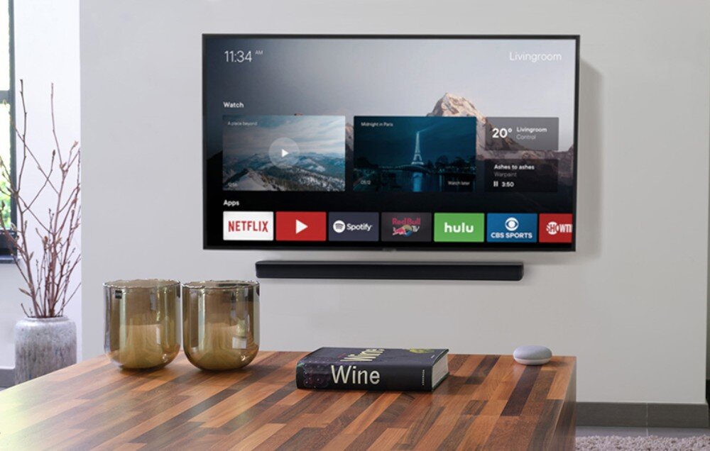 Uchwyt do soundbara ONE FOR ALL WM5310 Telewizor z włączonym menu aplikacji zamontowany na ścianie z głośnikiem poniżej, widoczny w nowoczesnym salonie