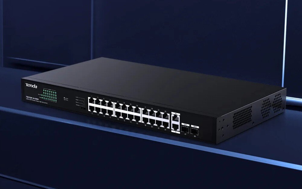 Na obrazie widoczny jest czarny switch sieciowy z 28 portami, z logo \'Tenda\' w lewym górnym rogu. Urządzenie znajduje się na ciemnym tle.