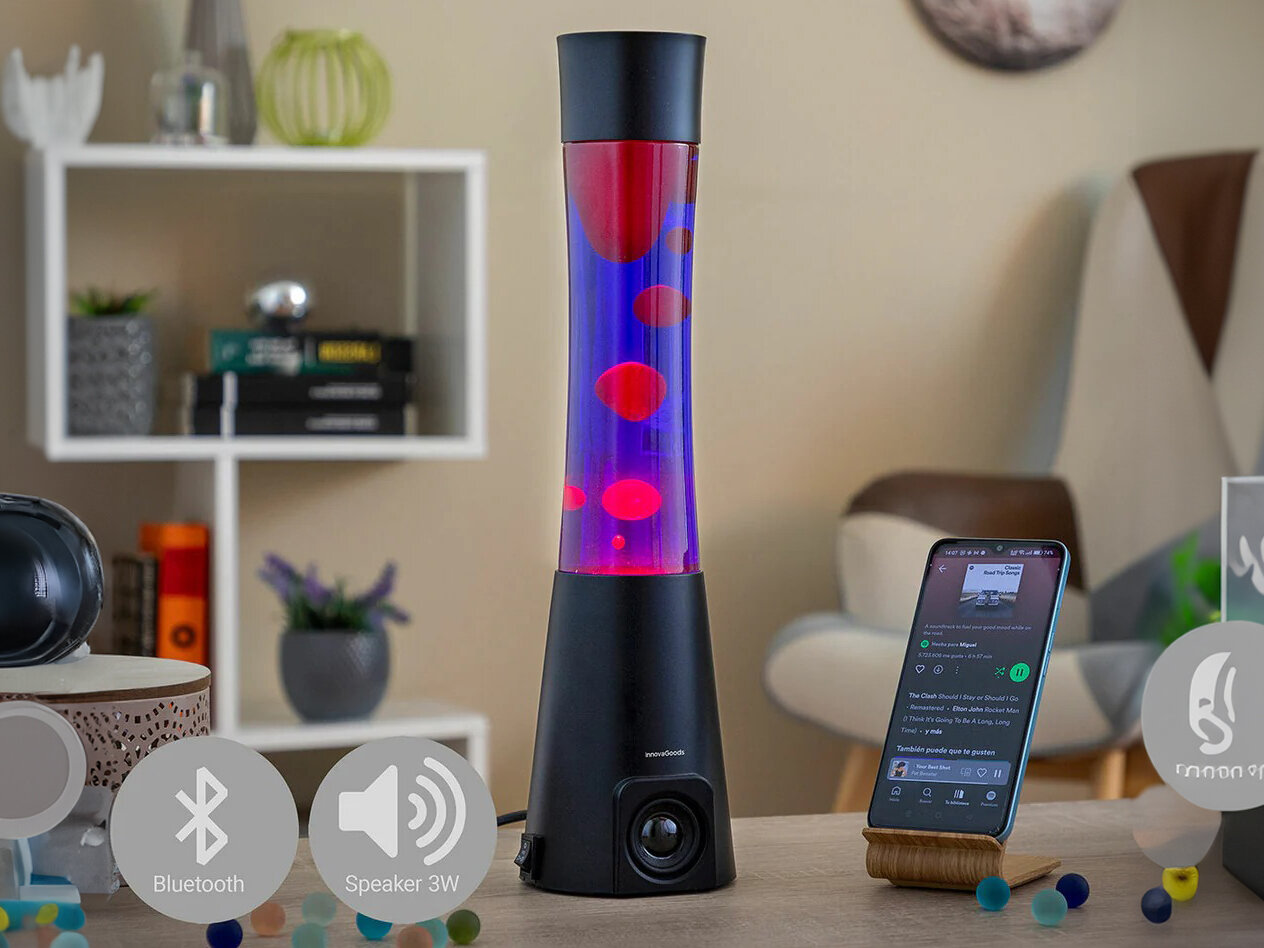 Lampka nocna INNOVAGOODS Lava Maglamp z głośnikiem Czarny, głośnik, Bluetooth, muzyka, relaks, Lampa lawa obok telefonu z opisem funkcji audio.