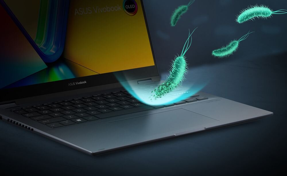 Wizualizacja technologii ASUS Antimicrobial Guard na laptopie ASUS VivoBook S 14 Flip – niebieska tarcza ochronna na klawiaturze i touchpadzie odbijająca zielone bakterie, symbolizująca ochronę antybakteryjną. - ASUS Antimicrobial Guard