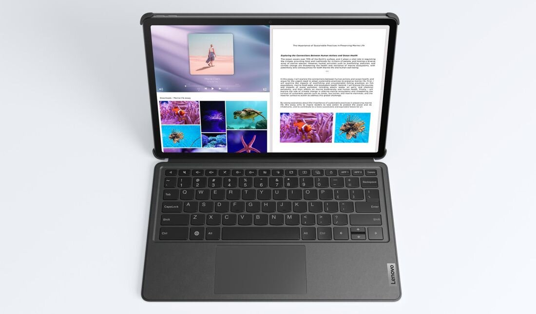 Tablet z klawiaturą, na ekranie wyświetlane są zdjęcia i tekst. Logo Lenovo widoczne na klawiaturze.