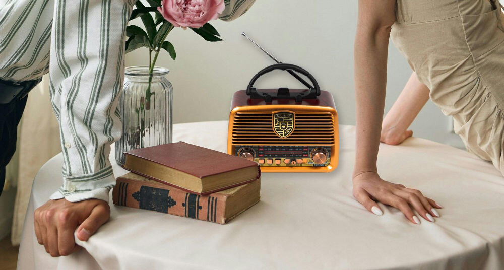 Radio BLOW RA10 powerbank port USB ładowanie urządzeń mobilnych, osoby opierające się o stolik, radio stojące na stoliku