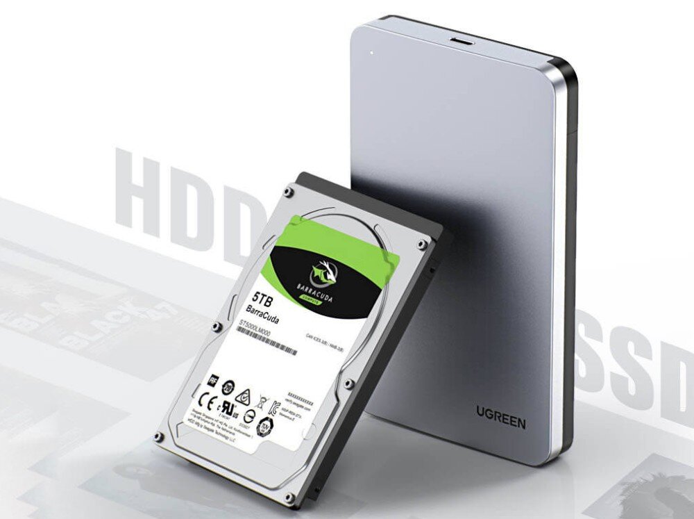 Obudowa dysku UGREEN CM300 Srebrna obudowa ustawiona pionowo obok wewnętrznego dysku twardego z zieloną etykietą 'Barracuda 5TB'. W tle widnieją napisy 'HDD' oraz 'SSD'