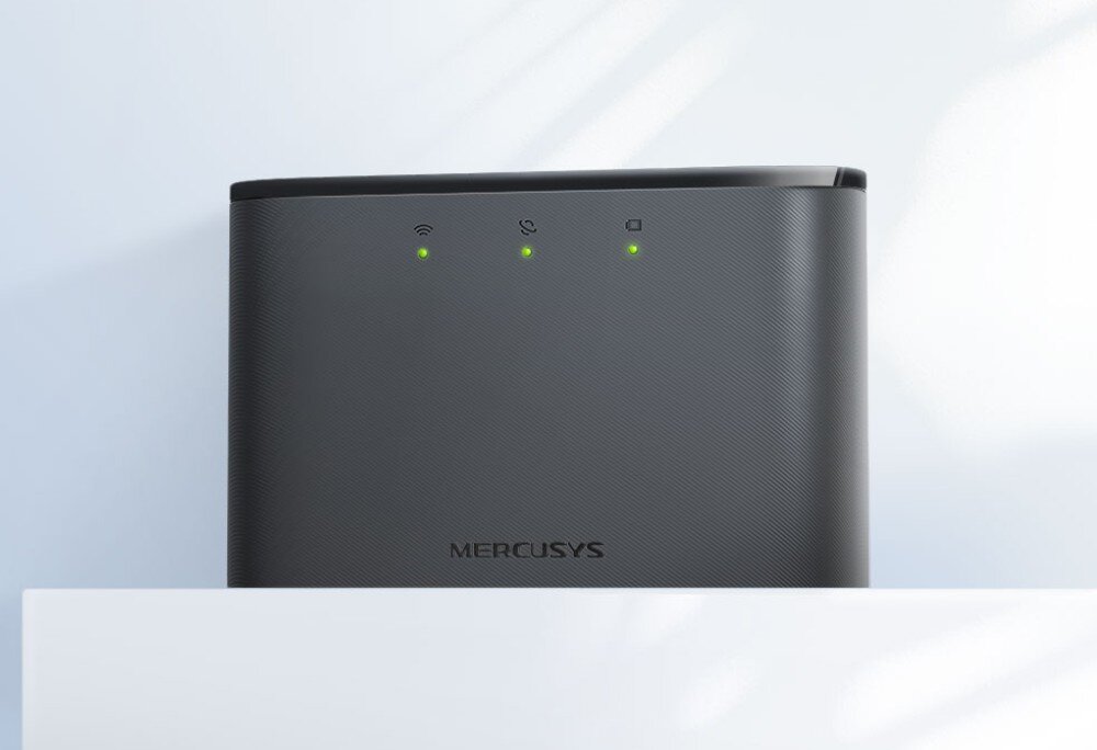 Router MERCUSYS MT110 Ciemnoszary router ustawiony na białej powierzchni z trzema świecącymi diodami LED sygnalizującymi aktywne połączenie. Tło w jasnych odcieniach z subtelnym cieniem, opis