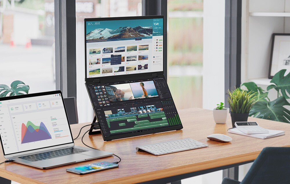 Monitor UPERFECT Ustation Delta Biurko przy oknie z laptopem, smartfonem i klawiaturą bezprzewodową, obok których stoi zestaw dwóch ekranów jeden nad drugim z otwartym programem do montażu wideo i stroną internetową, przekątna, zastosowanie, wykorzystanie