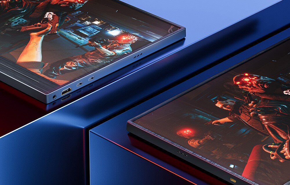 Monitor UPERFECT UGame J5 Dwa monitory przenośne ułożone na płaskiej powierzchni pokazujące kadr z gry z postaciami o świecących czerwonych oczach, widoczne porty HDMI i USB-C, porty, gniazda, głośniki, kompatybilność