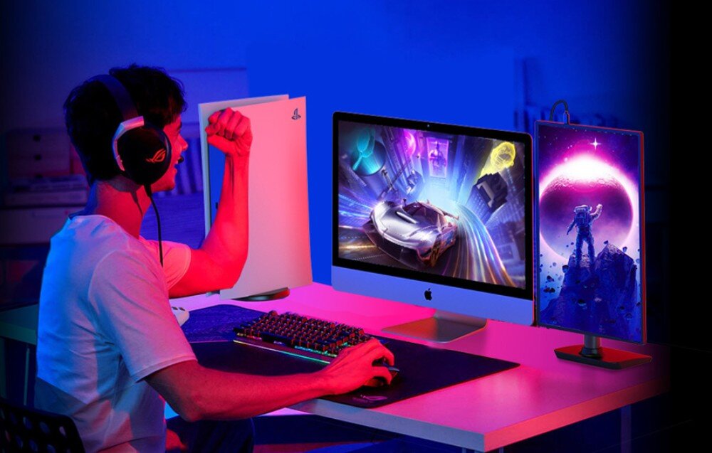 Monitor UPERFECT UGame C2 Mężczyzna w słuchawkach siedzący przy biurku z konsolą, komputerem i przenośnym monitorem wyświetlającym astronautę na tle planety, opis