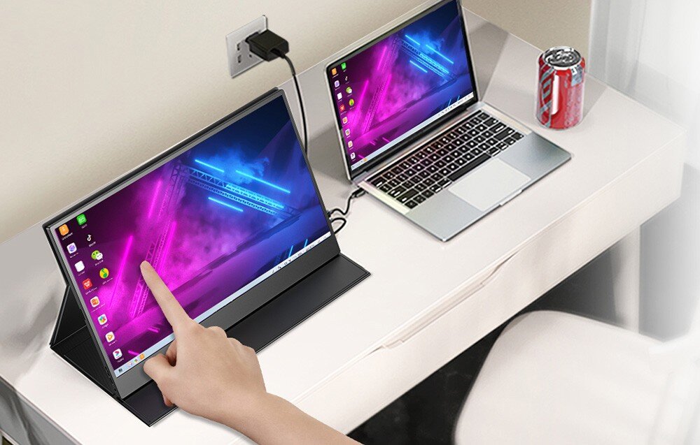 Monitor UPERFECT USetup E7 Ręka dotykająca ekran przenośnego monitora podłączonego do laptopa stojącego na biurku obok puszki napoju, opis