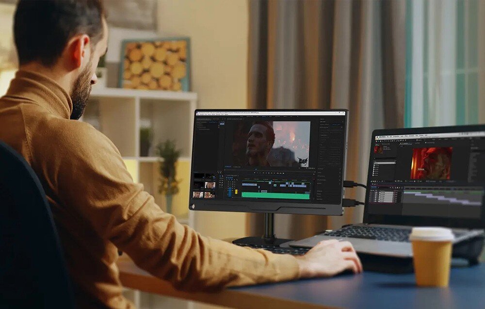 Monitor UPERFECT UFilm A17 Mężczyzna siedzący przy biurku pracuje na komputerze, a obok laptopa stoi dodatkowy ekran wyświetlający program do montażu wideo, opis