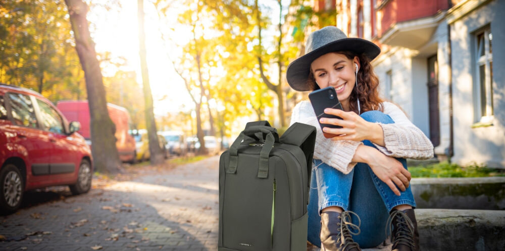 Plecak na laptopa SAMSONITE Guardit Classy 14.1
elegancja i funkcjonalność, kobieta siedząca na murku, a obok niej stoi plecak