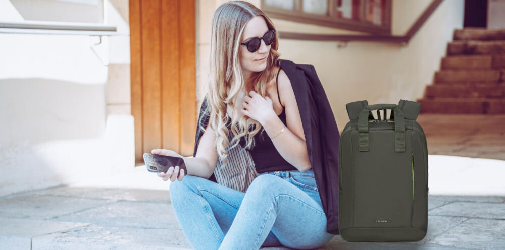 Plecak na laptopa SAMSONITE Guardit Classy 14.1
Stylowy design, który łączy prostotę i elegancję, stonowany wygląd, podkreślony subtelnymi detalami i delikatnymi zamkami,
siedząca na ziemi kobieta, trzymająca w ręce smartfon, a obok niej stoi plecak
