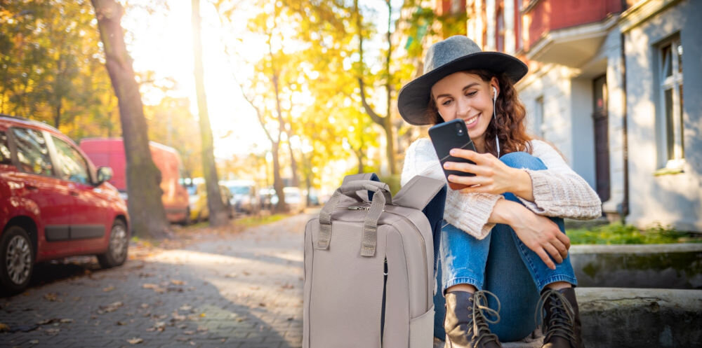 Plecak na laptopa SAMSONITE Guardit Classy 14.1
elegancja i funkcjonalność, kobieta siedząca na murku, a obok niej stoi plecak