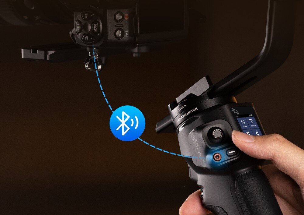 Gimbal ZHIYUN Crane 4 Combo Dłoń użytkownika naciska przycisk na uchwycie stabilizatora, a niebieska ikona Bluetooth wskazuje na łączność bezprzewodową, łączność Bluetooth, sterowanie, przyciski