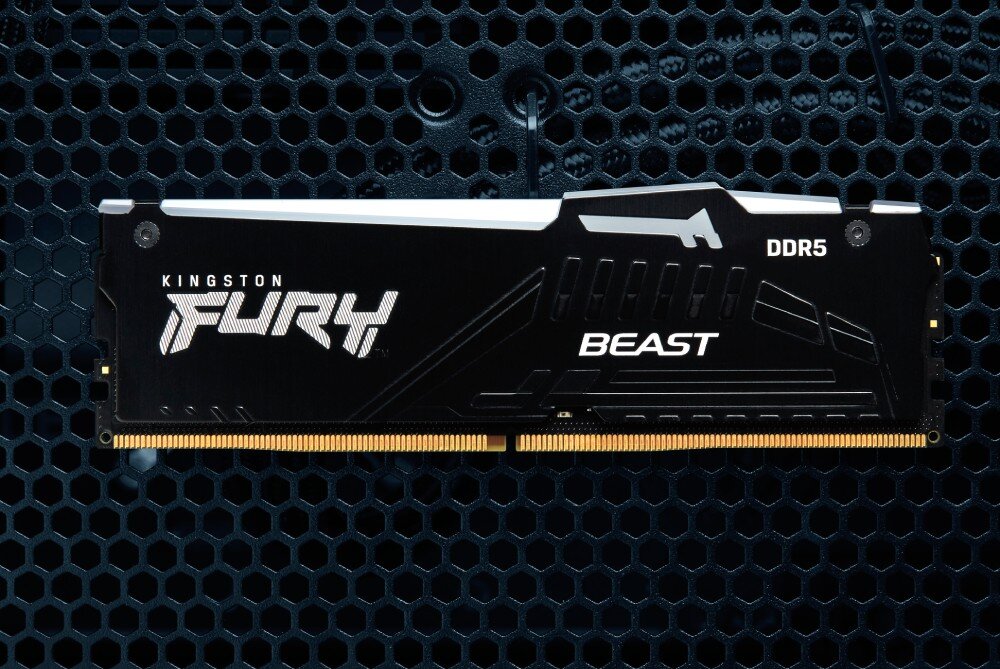 Pamięć RAM KINGSTON Fury Beast RGB Pojedynczy czarny moduł pamięci z widocznym logo producenta leżący na czarnej metalowej siatce