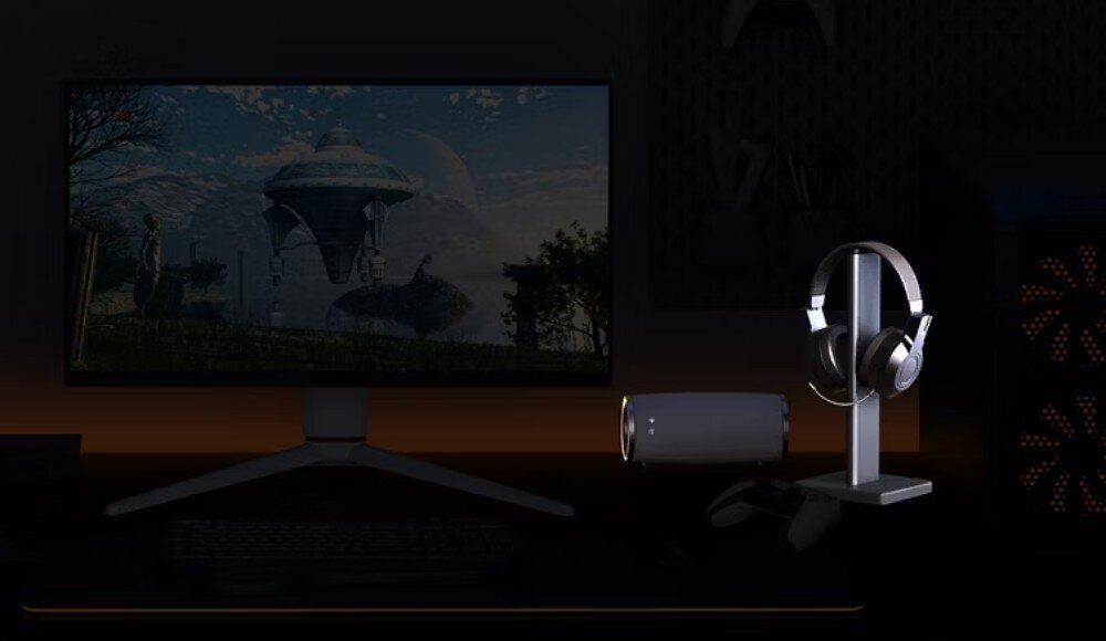 Monitor BENQ Mobiuz EX321UX Biurko w przyciemnionym pokoju z monitorem, na którym wyświetlana jest scena z gry. Obok monitora stoi stojak na słuchawki oraz głośnik, dźwięk 7.1, przetwornik DAC, audio