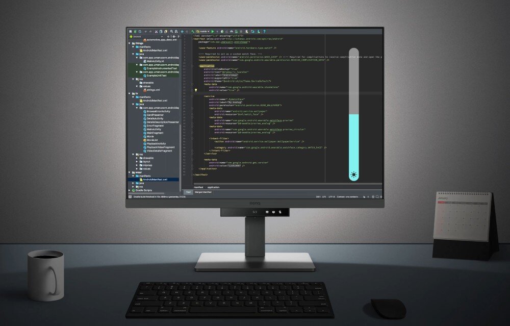 Monitor BENQ RD280U Monitor ustawiony na biurku z klawiaturą, myszką i kubkiem. Na ekranie środowisko Android Studio z kodem XML oraz aktywnym suwakiem regulacji jasności, podświetlenie tyłu, regulacja jasności