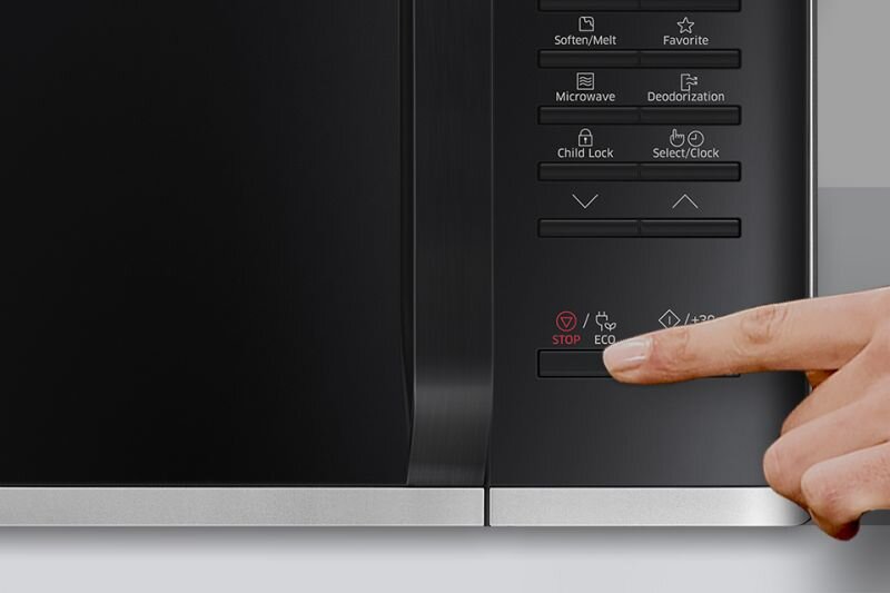 Panel sterowania kuchenki mikrofalowej z widocznymi przyciskami i tekstem: \'Soften/Melt\', \'Favorite\', \'Microwave\', \'Deodorization\', \'Child Lock\', \'Select/Clock\', \'STOP\', \'ECO\'. Palec naciska przycisk \'STOP\'.