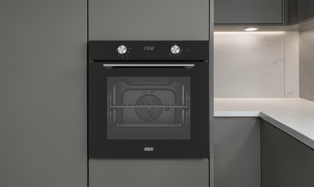 Piekarnik FRANKE Maris FMA 86 H BK 116.0606.098 Widok z boku pokazuje piekarnik z uchylonymi drzwiczkami w stylowej kuchni. W tle widoczne jest duże okno doświetlające pomieszczenie