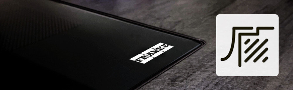 PŁYTA FRANKE Smart FSM 302 I BK Krawędź płyty indukcyjnej z logo „FRANKE” na tle kamiennego blatu. Obok znajduje się ikonka symbolizująca dopasowanie lub integrację z powierzchnią montaż na równi z blatem design łatwe czyszczenie
