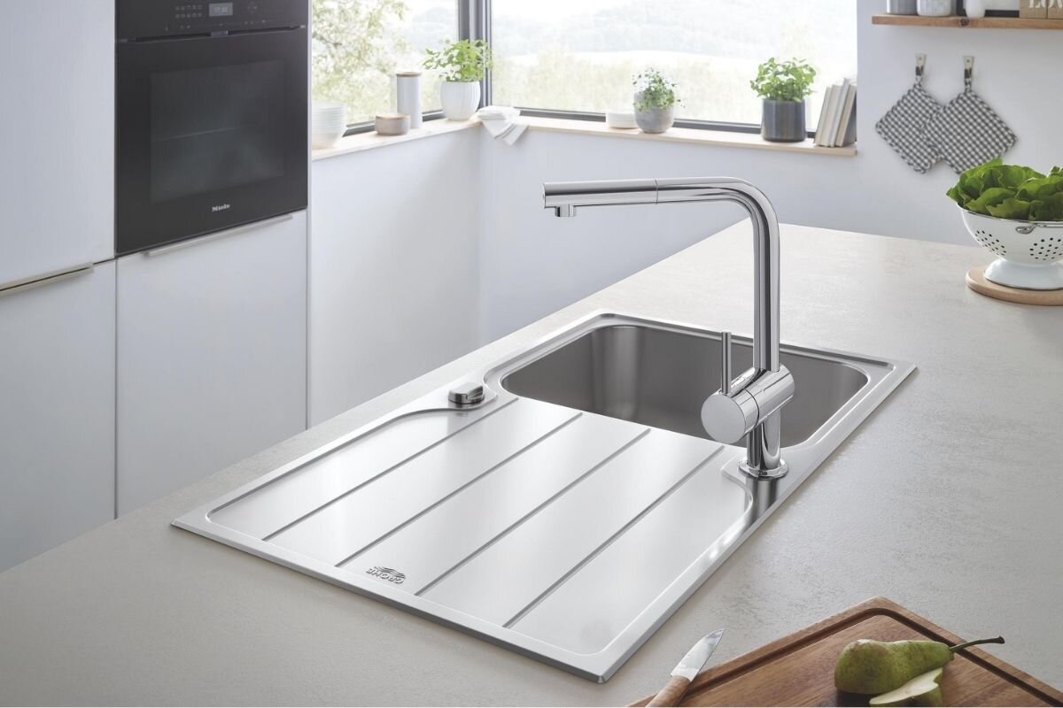 BATERIA KUCHENNA GROHE MINTA 32168000 Chromowa bateria kuchenna zamontowana przy czarnym zlewozmywaku w eleganckiej kuchennej aranżacji