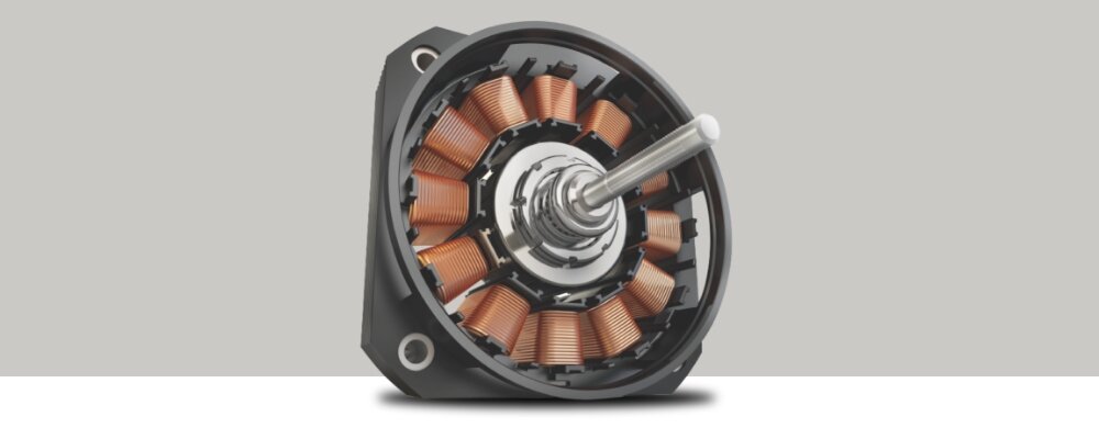 PRALKO-SUSZARKA BEKO BMM5DFO5741W 4.jpg przedstawia silnik pralki typu inwerterowego pokazany w dużym zbliżeniu na jednolitym, szarym tle. Widać okrągły korpus z miedzianymi uzwojeniami ułożonymi promieniście oraz centralny metalowy wał, co podkreśla nowoczesną i trwałą konstrukcję napędu ProSmart Inverter silnik bezszczotkowy pralko‑suszarka BEKO cicha praca energooszczędna trwałość oszczędność prądu ekologiczne pranie