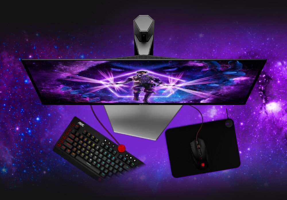 Monitor AOC Agon Pro AG326UD Widok z góry na monitor i zestaw peryferiów, w tym klawiaturę, myszkę i podkładkę na ciemnym tle z elementami kosmicznymi, stojak, zarządzanie kablami, mocowanie VESA