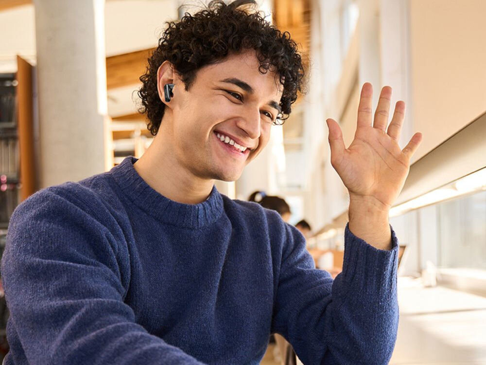 Słuchawki AWEI TP97 Bluetooth ANC aktywna redukcja hałasu, osoba z wyciągniętą ręką z założonymi słuchawkami