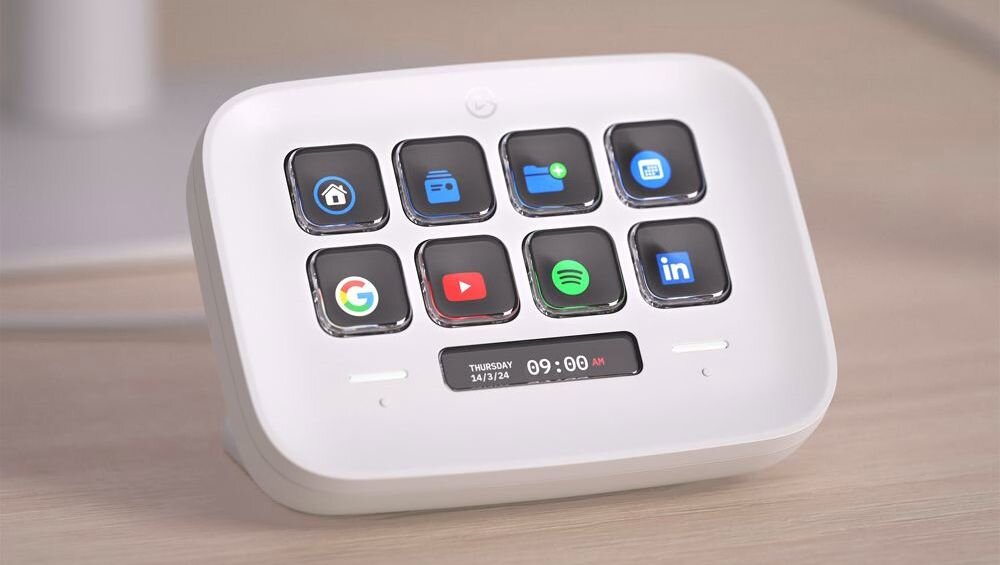 Biały panel Elgato Stream Deck z ośmioma przyciskami LCD stoi na biurku, pokazując skróty aplikacji i zegar 