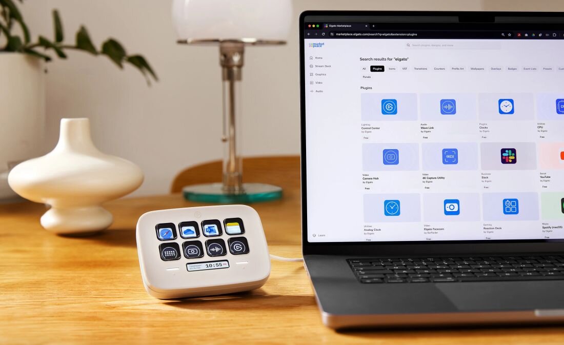 Panel Elgato Stream Deck stoi obok laptopa na drewnianym biurku, a ekran laptopa wyświetla stronę z wtyczkami - design i zaokrąglone narożniki  