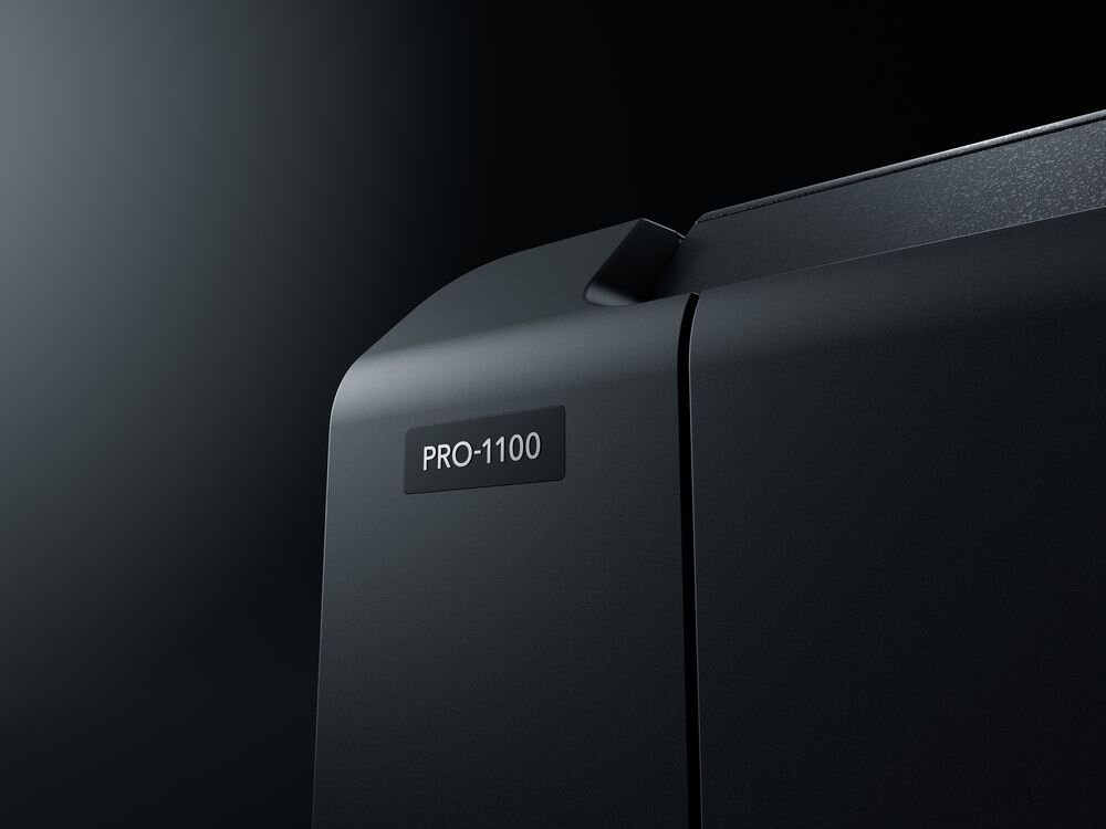 Drukarka CANON imagePROGRAF PRO-1100 Wi-Fi zbliżenie na napis z modelem na drukarce czarne tło funkcje planowania zużycia energii ograniczenie marnowania prądu obniżenie kosztów