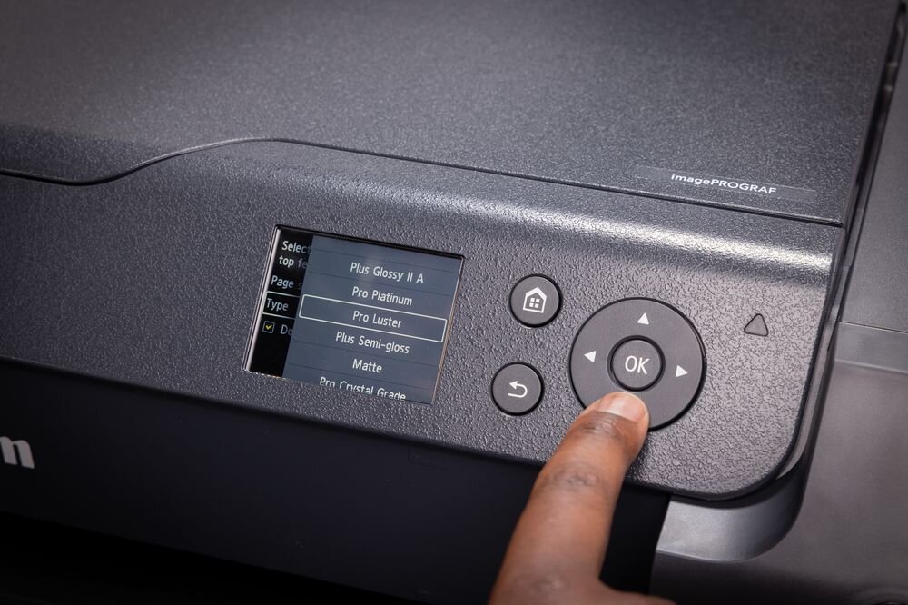 Drukarka CANON imagePROGRAF PRO-1100 Wi-Fi zbliżenie na ekran palec na przycisku kolorowy ekran LCD przejrzysty interfejs skraca czas potrzebny na konfigurację