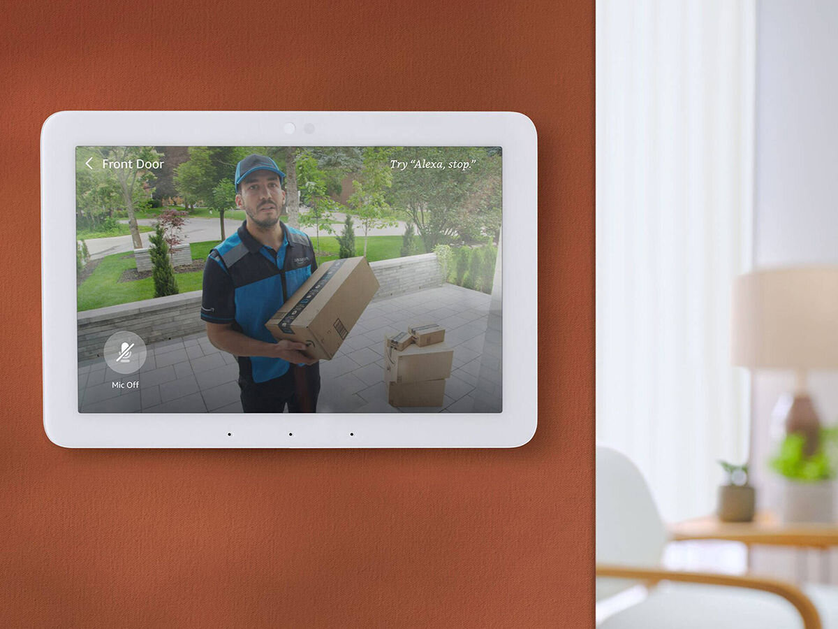 Asystent głosowy AMAZON Echo Hub 8 Biały, bezpieczeństwo, prywatność, wbudowane, monitorowanie, asystent zamontowany do ściany korytarza, w tle pokój gościnny