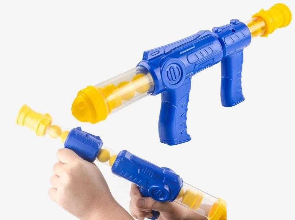 Gra plenerowa EXTRALINK Głodna kaczka Zbliżenie na dwa niebiesko-żółte pistolety pneumatyczne na kulki piankowe. Jeden pistolet jest pokazany w całości z widocznymi wewnątrz kaczuszkami-pociskami, a drugi jest trzymany w dłoniach, prezentując mechanizm ładowania.