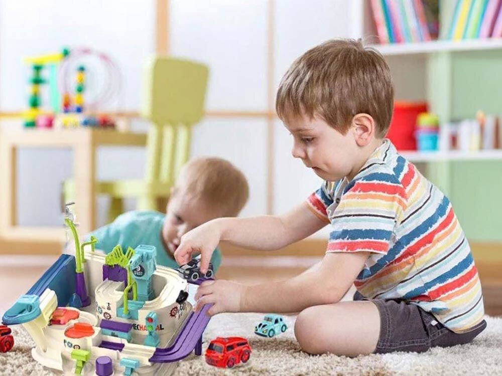 Tor samochodowy EXTRALINK Inteligentny EX.37605 dzieci bawiące się torem samochodowym w pokoju dziecięcym na dywanie