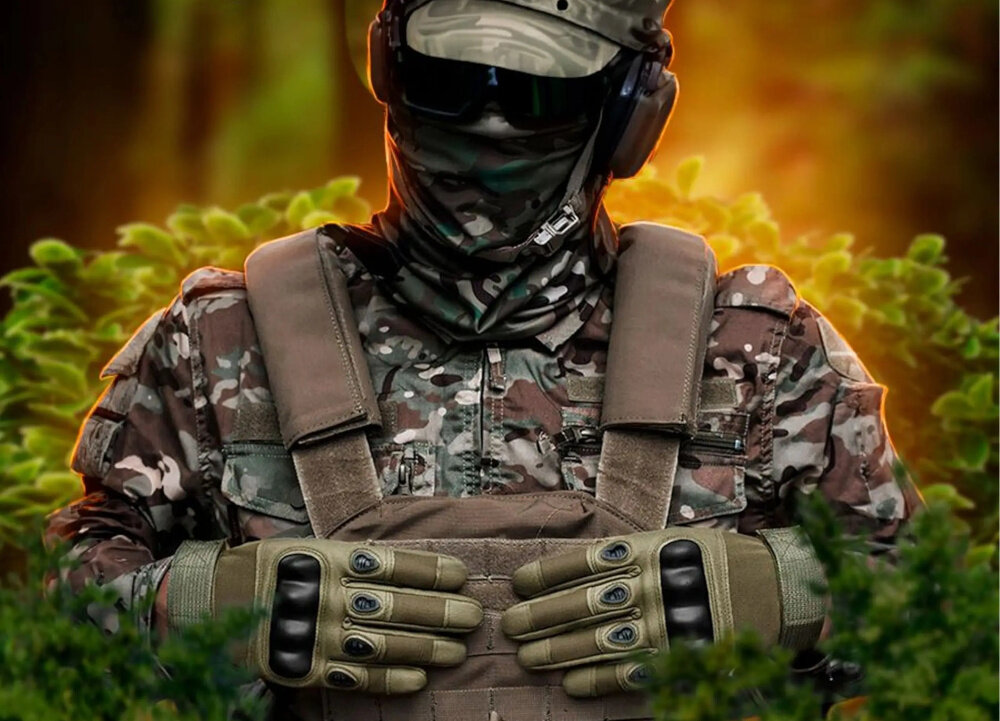 Rękawice taktyczne EXTRALINK MIL-681 (rozmiar XL) Zielony osoba w mundurze w masce ma założone rękawice na dłoniach w tle rośliny do zadań taktycznych uniwersalne zastosowanie bezpieczeństwo wygoda